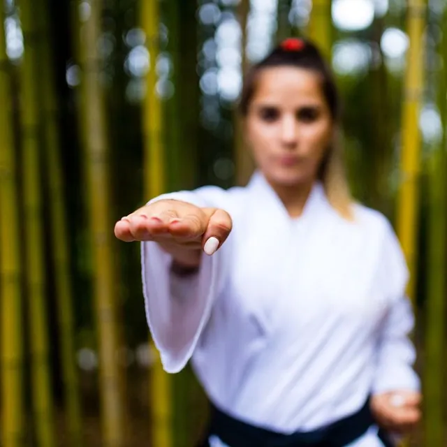 mujer desenfocada con mano extendida pose aikido